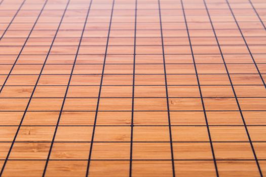 Empty and brown Chinese go game board.