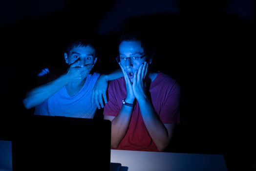 Two guys in front of a computer screen completely shocked at what they see