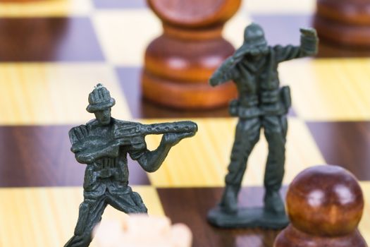 Miniature toy soldier on chess board.