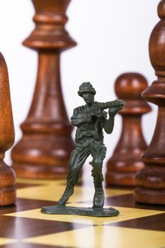 Close up view of miniature toy soldier on chess board.