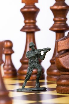 Close up view of miniature toy soldier on chess board.