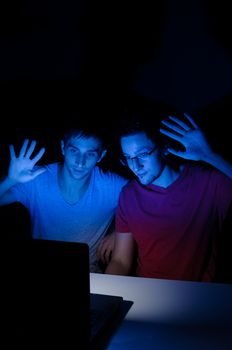 Two guys greeting someone through a video chat