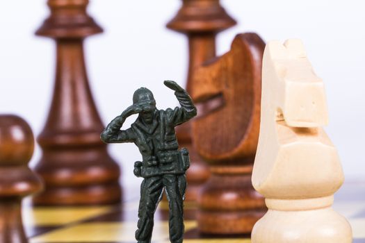 Miniature toy soldier on chess board.