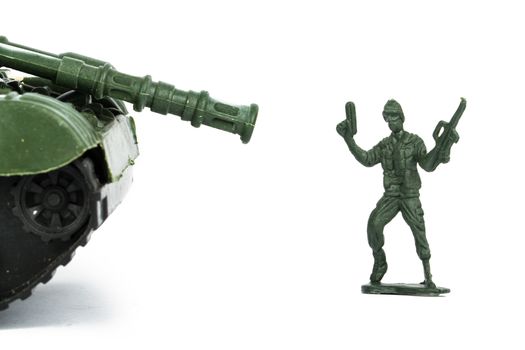 Miniature toy tank and soldier, isolated on white background.