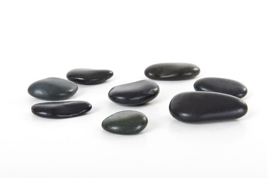 Black massage stones, isolated on white background.