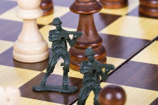 Close up view of miniature toy soldiers on chess board.