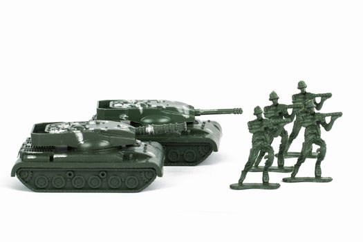 Miniature toy tank and attacker soldiers, isolated on white background.