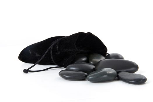 Set of massage stones and black case, isoalted on white background.