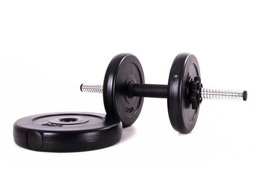 Black gym barbell, dumbbell and disks, isolated on white background.