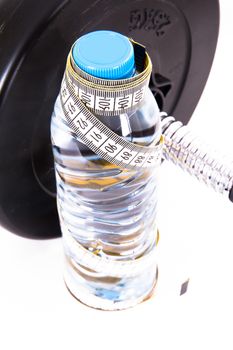 Plastic water bottle with tape measure and dumbbell, barbell, isolated on white background.