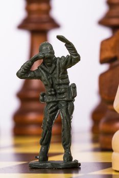 Close up view of miniature toy soldier on chess board.