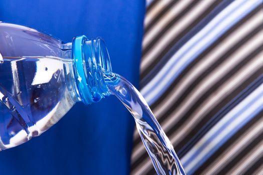 Water pouring from plastic bottle by businessman.