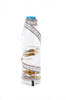 Plastic water bottle and tape measure, isolated on white background.