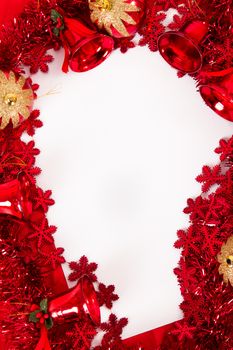 Christmas ornaments, bells, balls, stars and text area on blank paper, sheet on red fabric.