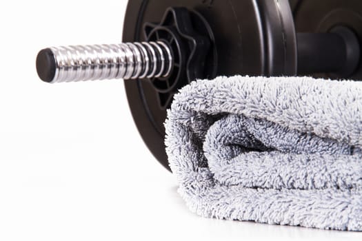 Black gym barbell, dumbbell with disks and blue towel, isolated on white background.