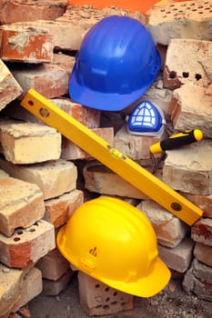 Bricks, trowel, level and helmet on work place 