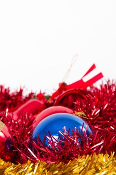 Red, yellow and blue christmas ornaments, balls, bells with space on top, isolated on white background.