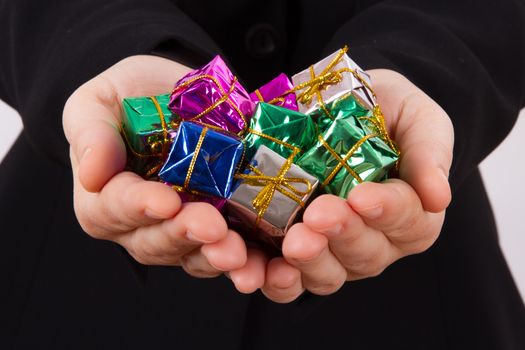 Hands extend colorful gift boxes.