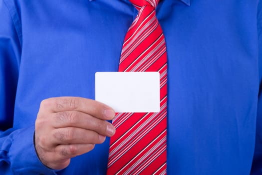 Businessman with red tie and blue shirt holding and showing blank, empty, white business card.