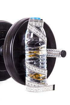 Plastic water bottle with tape measure and dumbbell, barbell, isolated on white background.