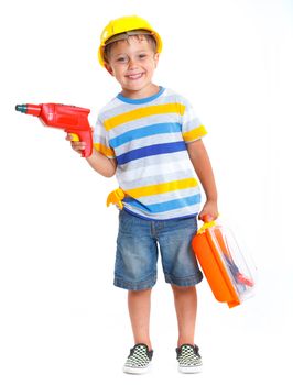 Little builder. Boy in a helmet plays in the builder with tools. Isolated over white.