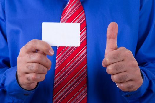 Businessman with red tie and blue shirt holding and showing blank, empty, white business card with approval, yes sign.