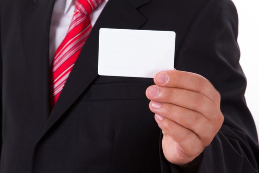 Businessman in dark suit and white shirt with red striped tie, shows white blank business card with space.