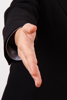 Business woman in suit extending hand to shake, isolated on white.