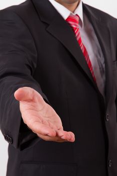 Businessman extends hand to shake or helping, isolated on white.