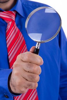 Businessman with red tie and blue shirt using magnifying glass and searching, isolated on white background.
