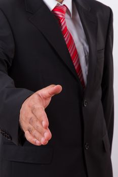Businessman in suit extending hand to shake.