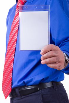 Businessman with red tie and blue shirt holding and showing blank, empty, white name tag, side view, isolated on white background.