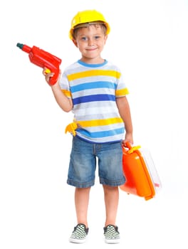 Little builder. Boy in a helmet plays in the builder with tools. Isolated over white.