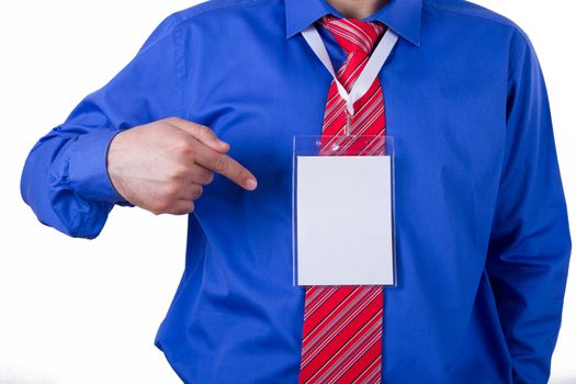 Businessman with red tie and blue shirt showing blank, empty, white name tag with his index finger, isolated on white background.