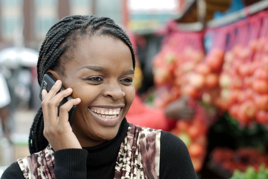 African or black American woman calling on mobile cellphone telephone in Alexandra township