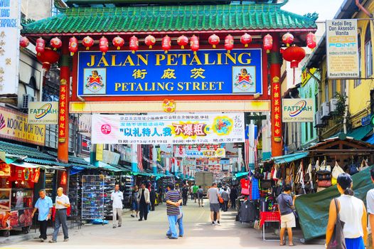 Kuala Lumpur, Malaysia - May 11, 2013: People at Petaling Street in Kuala Lumpur, Malaysia. The street is a long market which specializes in counterfeit clothes, watches and shoes. Famous tourist attraction 