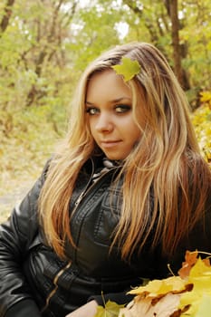 Portrait of a beautiful young blonde lying on the foliage