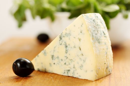 a large piece of blue cheese and black olives