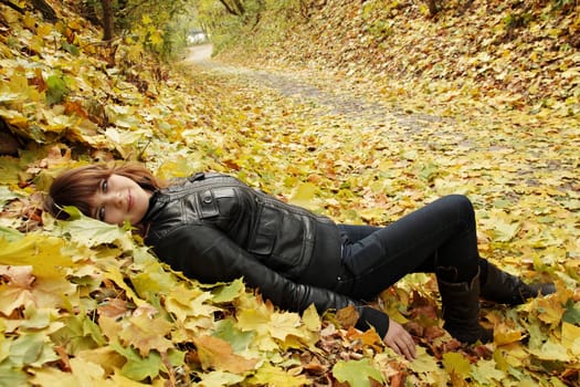 beautiful young woman lying on the foliage