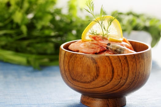 boiled shrimp with lemon and dill in a wooden bowl