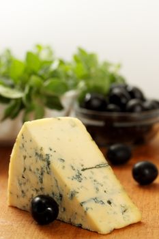 a large piece of blue cheese and black olives