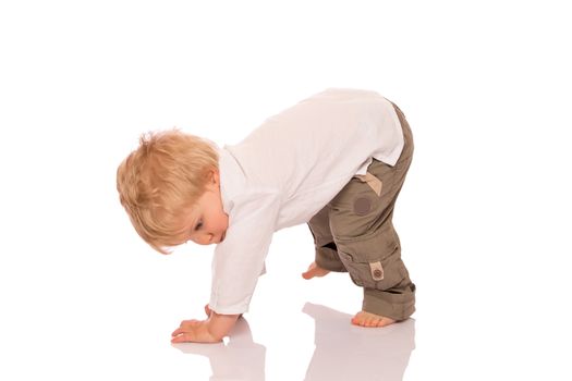 Young boy learning to walk. Isolated on white background