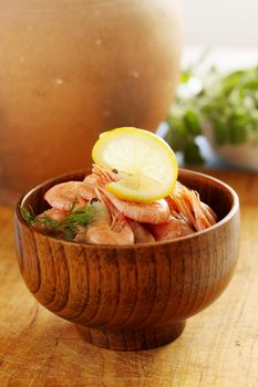 boiled shrimp with lemon and dill in a wooden bowl