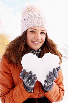 woman holds a heart of ice in the hands of