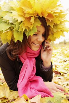 Woman in autumn wreath speaks on the phone