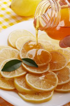 pour honey lemon slices on a plate