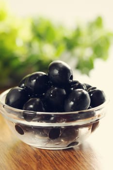 Black olives in a bowl transparent and lettuce