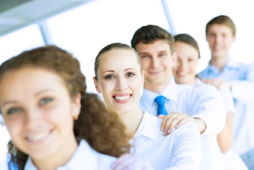 portrait of a young business woman standing in line with colleagues, concept of teamwork