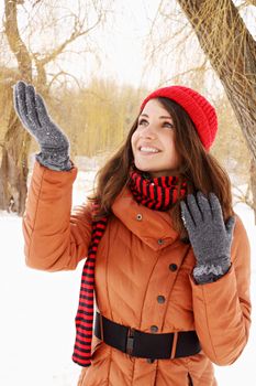  A young woman catches snowflakes in hand