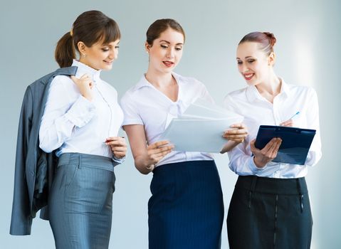 group of business women discussing documents together, teamwork in business